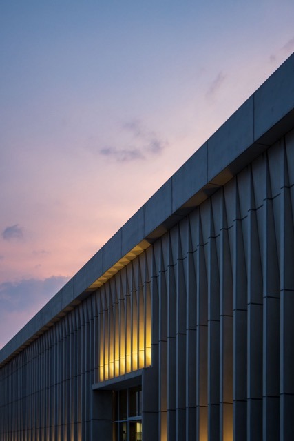 Dusk falls, the city's commercial buildings create an artful skyline with vibrant reflections.